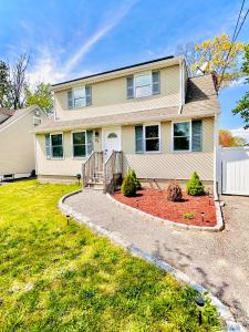 a large house with a driveway in front of it at Peaceful home equal to a sound sleep! in Mastic Beach
