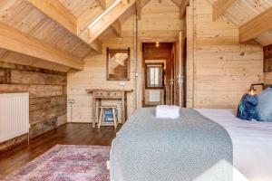 ein Schlafzimmer mit einem Bett in einem Holzzimmer in der Unterkunft Bluebell Lodge in Benson