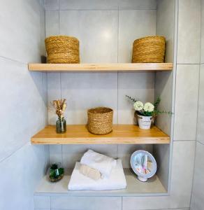 baño con estanterías de madera con cestas y toallas en GIJÓN ÁTICO PLAZA, en Gijón