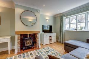 sala de estar con chimenea y espejo en Walnut Cottage, en Brackley