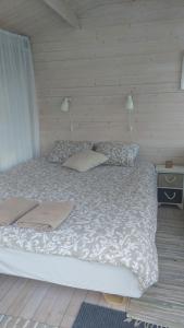a bedroom with a bed with a white comforter and pillows at Jaagu majad in Suuremõisa