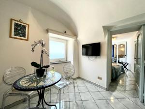 a living room with a table and chairs at Suite Apartment con Giardino in Piazzetta in Capri