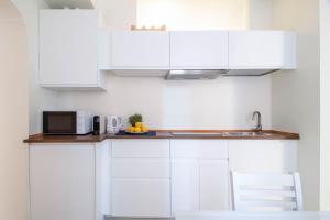 cocina blanca con armarios blancos y microondas en ALPORTO58 en Camogli
