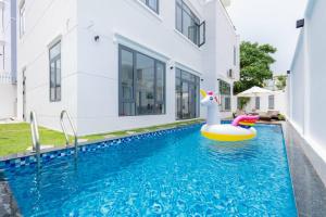 uma piscina com um brinquedo de piscina numa casa em Palm Villa 10 Near Beach em Vung Tau