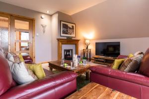 un soggiorno con mobili in pelle rossa e TV di Mountain View Lodge - Seasgair Lodges a Grantown on Spey