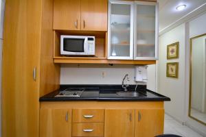 a kitchen with a sink and a microwave at Garvey Park 1031 - Biensky Imóveis in Brasilia
