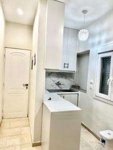eine Küche mit weißen Schränken und einer weißen Tür in der Unterkunft Shades of Zante 3 in Alykes