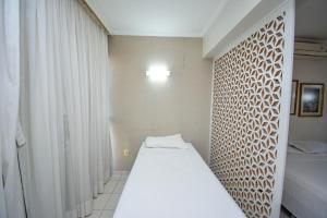 a small room with two beds and a window at Garvey Park 1031 - Biensky Imóveis in Brasilia