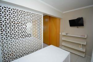 a room with a bed and a tv on a wall at Garvey Park 1031 - Biensky Imóveis in Brasilia