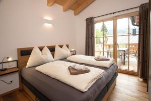 a bedroom with two beds and a balcony at Dachstein Chalet in Russbach am Pass Gschütt