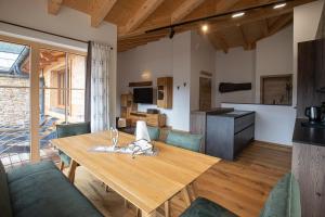 eine Küche und ein Esszimmer mit einem Holztisch und Stühlen in der Unterkunft Dachstein Chalet in Russbach am Pass Gschütt