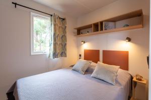 un dormitorio con una cama y una ventana en Le Cycas, mobil-home neuf avec sa vue dégagée sur les vignes et la mer, en Hyères