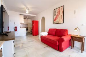 a living room with a red couch and a kitchen at 28 Rooftop apartment close to the beach Sabinillas in San Luis de Sabinillas