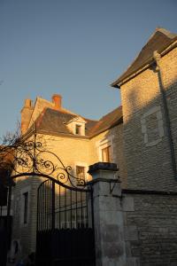 een oud gebouw met een poort ervoor bij L'Escapade Place Voltaire in Vermenton