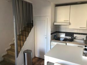 a kitchen with a staircase leading up to a stair case at Maison Triplex du jardin des plantes in Rouen