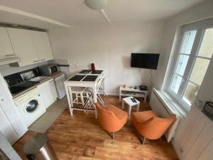a kitchen with orange chairs and a table and a sink at Maison Triplex du jardin des plantes in Rouen