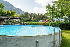 a large swimming pool in a yard with mountains in the background at Ferienhof Turmwirt Gala in Lana