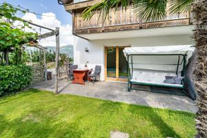 a backyard with a bed and a table at Ferienhof Turmwirt Gala in Lana