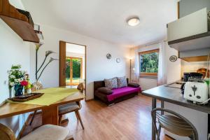 uma sala de estar com um sofá roxo e uma mesa em Ferienhof Turmwirt Gala em Lana
