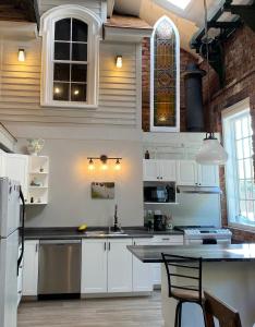 uma cozinha com armários brancos e uma bancada em Olde Foundry Apt em Pictou