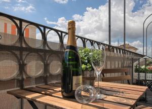 a bottle of wine sitting on a wooden table with glasses at Relais Quattro Fontane in Rome