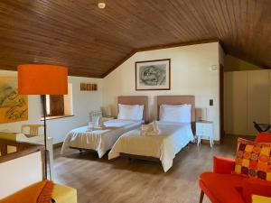 a bedroom with two beds and a couch at Vida-Vi, Country House and B&B in Santa Catarina