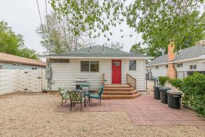 uma casa com uma porta vermelha e um pátio com cadeiras em Cherry Blossom I - Downtown Cottage Backyard Retreat em Fruita