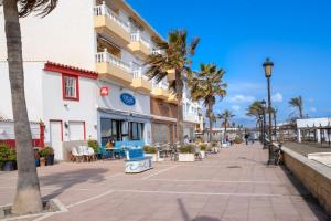 une rue en face d'un bâtiment avec des palmiers dans l'établissement 29 Close to the beach, 2 bedroom Sabinillas Manilva Andalusia, à San Luis de Sabinillas