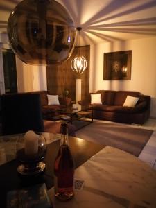ein Wohnzimmer mit einem Sofa und einem Tisch mit einer Flasche in der Unterkunft Schicke 2 Zimmer Wohnung nah an Stuttgart Messe Flughafen in Ostfildern