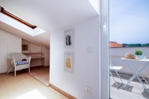 Cette chambre dispose d'un balcon avec une table et une fenêtre. dans l'établissement APPARTAMENTO LA MANSARDINA, à Sestri Levante