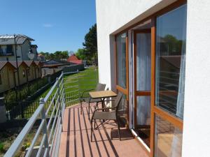 a balcony of a house with a table and chairs at Pogodna 3B in Mielno