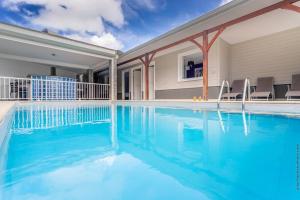 - une piscine d'eau bleue dans une maison dans l'établissement Villa Kaju : grande piscine et proche plage, à Sainte-Luce