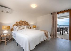 una camera con un grande letto bianco e un balcone di 2 Penthouse Duquesa Marina Manilva Andalucia Spanien a Manilva