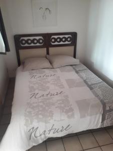 sypialnia z łóżkiem z białą kołdrą w obiekcie mini maison mini budget w mieście Soulac-sur-Mer