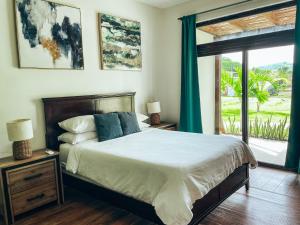 a bedroom with a bed and a large window at El Sitio Village in Playa Venao