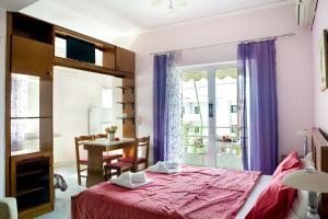 een slaapkamer met een bed, een tafel en een raam bij Sunny Apartments - ex Zoi Studios in Daratso