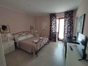 Dormitorio con cama, escritorio y TV en GArt Riviera B&B en Pescara