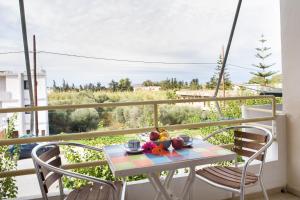 een tafel met een fruitschaal op een balkon bij Sunny Apartments - ex Zoi Studios in Daratso