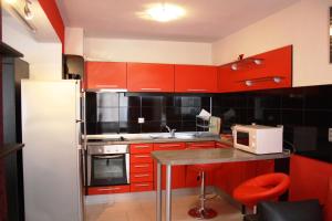a kitchen with red cabinets and a white refrigerator at Zoya Guest House in Ravda