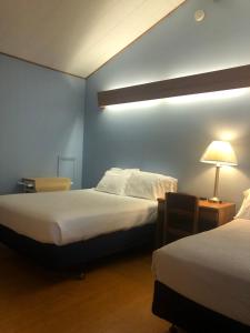 um quarto com duas camas e um candeeiro sobre uma mesa em Executive Motel em Old Orchard Beach