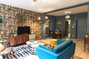 a living room with a blue couch and a tv at Le Vintage coup de coeur ! in Mons