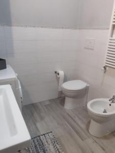 a white bathroom with a toilet and a sink at La Girandola in Grosseto