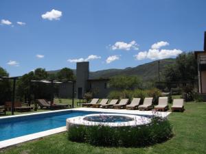 einen Pool mit Liegestühlen und einem Pool in der Unterkunft El algarrobo escondido in La Falda