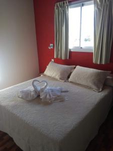 a bed with two white towels on top of it at El algarrobo escondido in La Falda