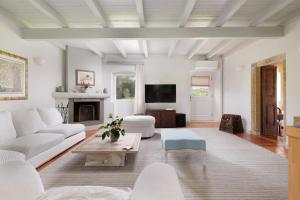 a living room with white furniture and a tv at Triklino Estate in Áfra