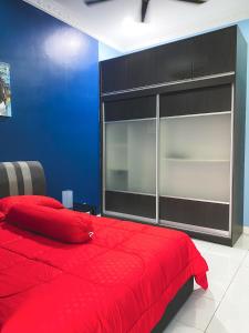 um quarto com uma cama vermelha e uma parede azul em DF ZaheenulFitri Homestay (Muslim Homestay) em Seremban