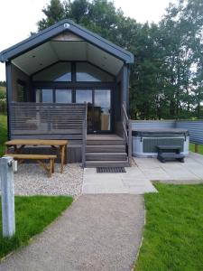 eine kleine Hütte mit einer Bank und einem Picknicktisch in der Unterkunft The Cuddies in Balloch