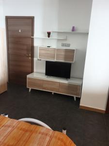 a living room with a tv and a desk with a tvictericterictericter at Oasi del benessere in Ilbono