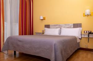 a bedroom with a large bed with white pillows at Hotel Tibur in Zaragoza