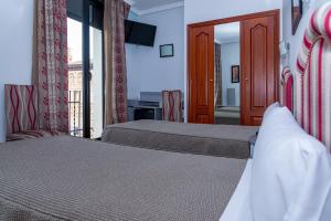 a hotel room with two beds and a television at Hotel Tibur in Zaragoza